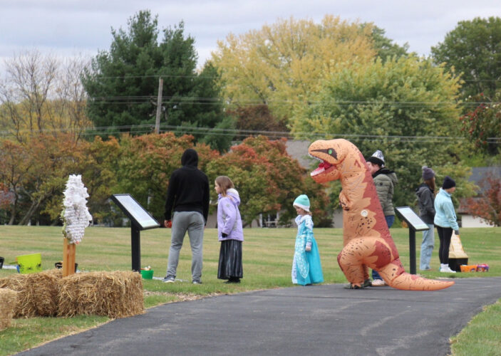 costumed people visit the storywalk during a Halloween event